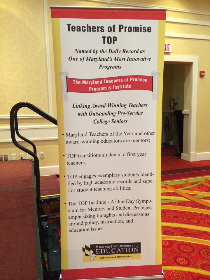 Teachers of Promise banner next to the stage in a hotel ballroom