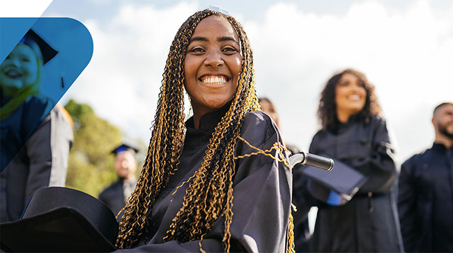 student in cap and gown smiling