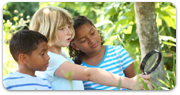 3 children outside with magnifying glass