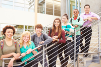 High School Students And Teacher Standing Outside Building