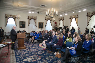 Maryland Governor Larry Hogan speaks at a podium in front of a seated audience.