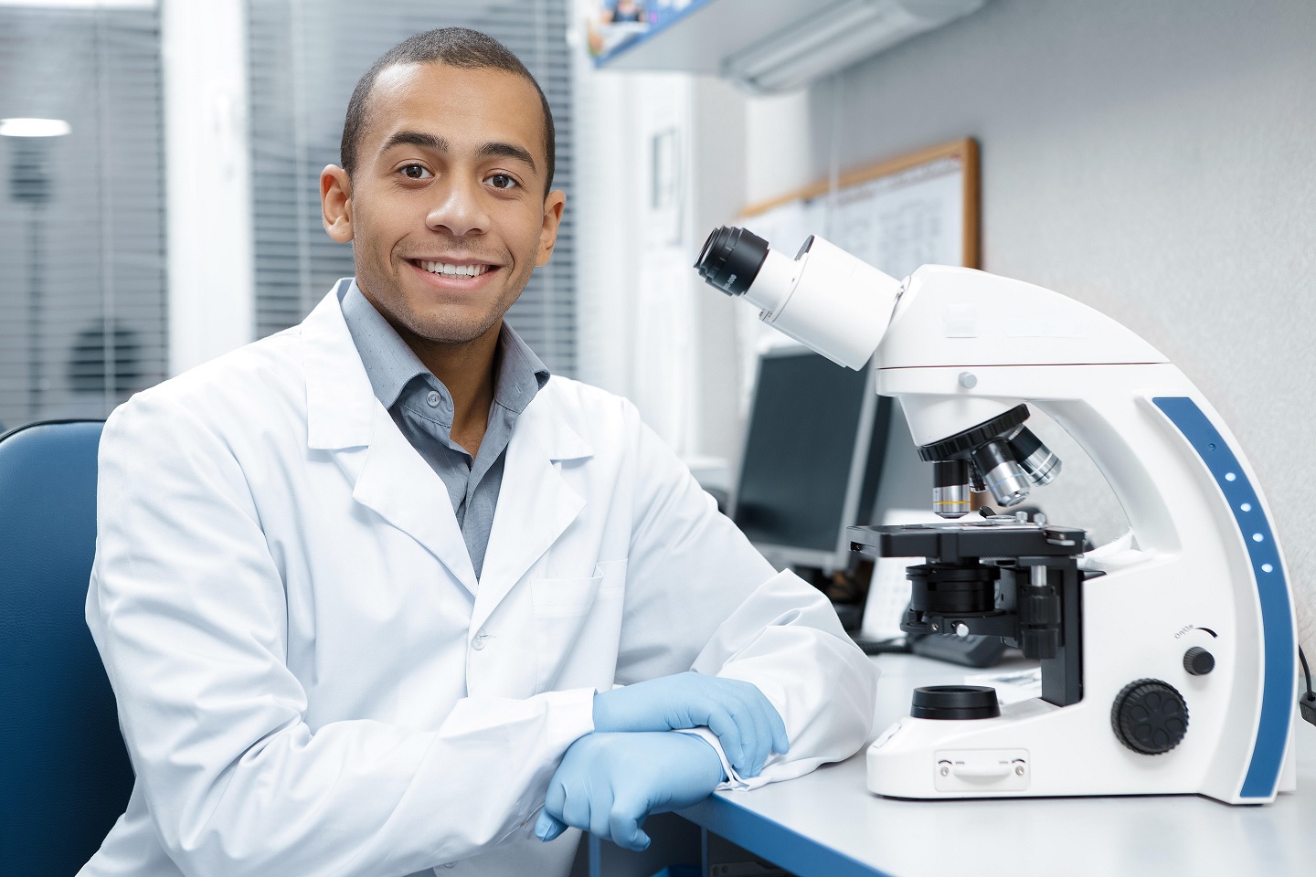 Professional male scientist working on his microscope at the lab