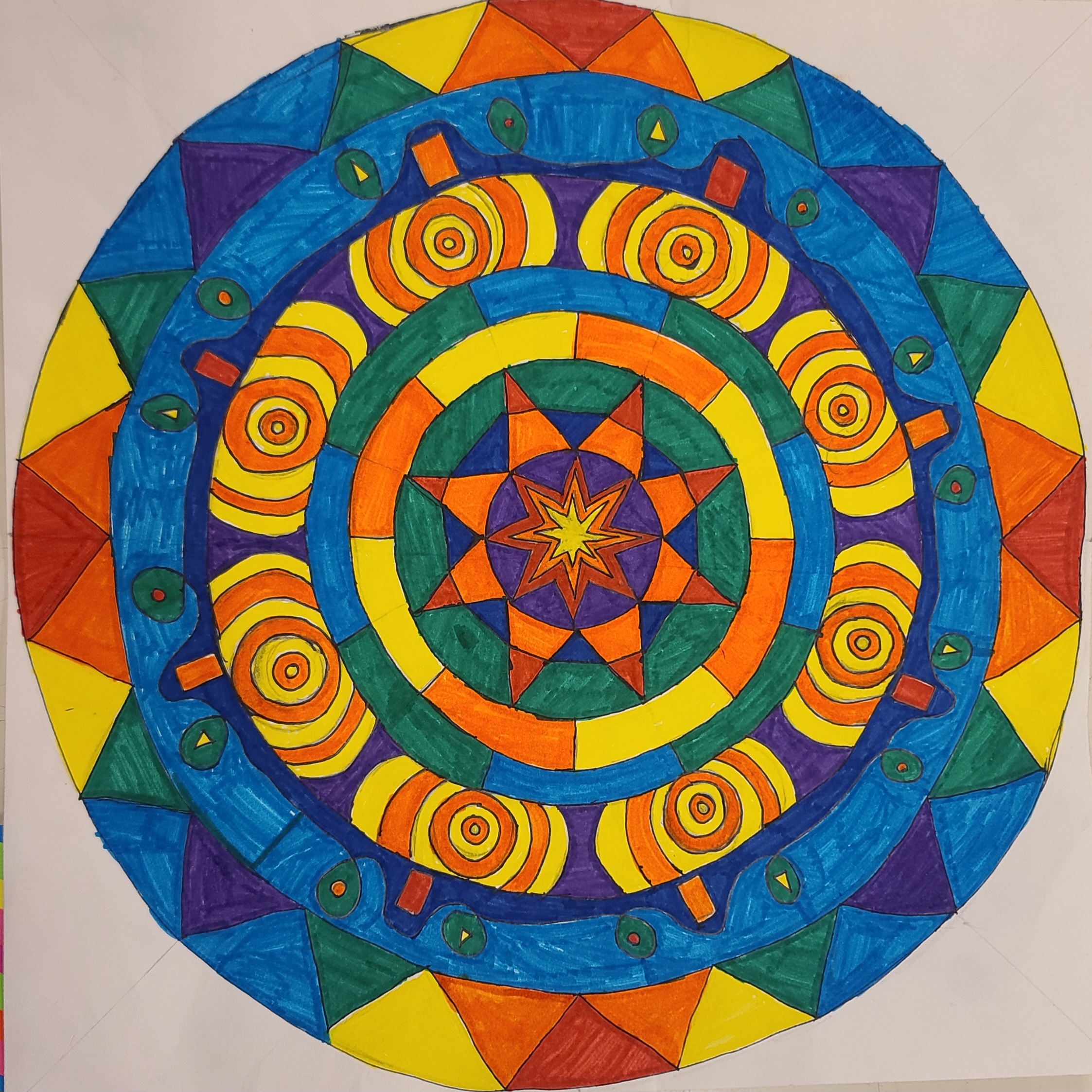 Image of a geometric pattern depicting the sun, using bright yellow, red, orange, and blue colors. Medium: marker.