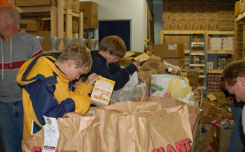 Students fill bags at a local food bank to be given to community residents in need.