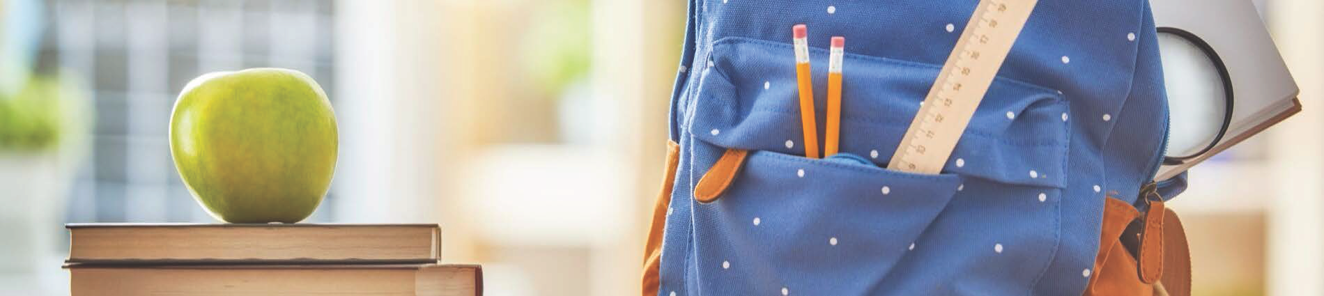 A backpack, books, and a green apple
